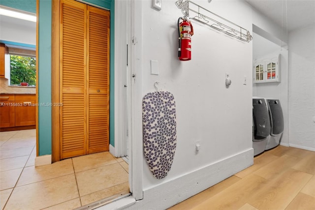 interior space with a closet, wood finished floors, baseboards, and separate washer and dryer