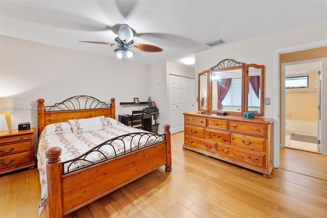 bedroom with visible vents, a closet, light wood-style flooring, and a ceiling fan