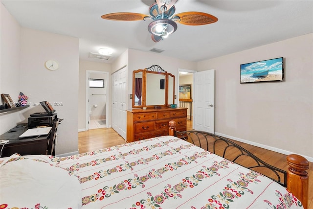 bedroom featuring ceiling fan, wood finished floors, visible vents, baseboards, and a closet