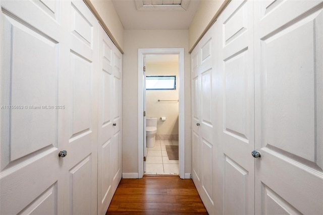 corridor with dark wood-style flooring and baseboards