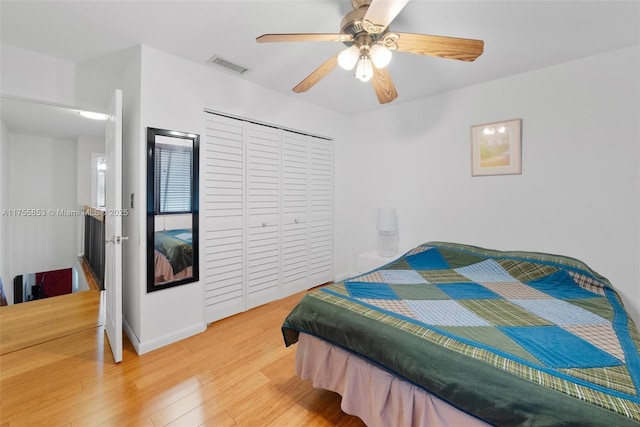 bedroom with a ceiling fan, a closet, visible vents, and wood finished floors