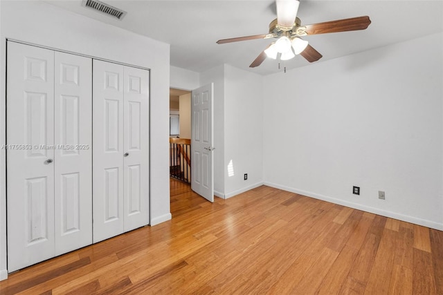 unfurnished bedroom with light wood-style flooring, a closet, visible vents, and baseboards