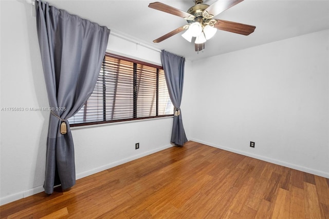 unfurnished room with a ceiling fan, baseboards, and wood finished floors