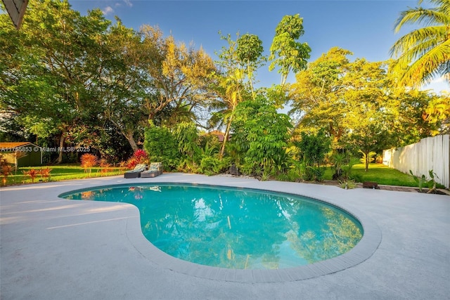 view of swimming pool with a fenced in pool, fence, a patio, and a lawn