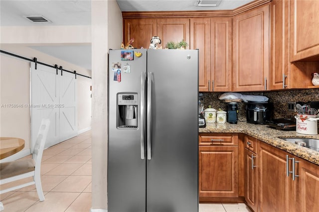 6830 SW 5th Ter, Miami, FL 33144 - kitchen with light tile patterned flooring, visible vents, brown cabinetry, and stainless steel fridge with ice dispenser