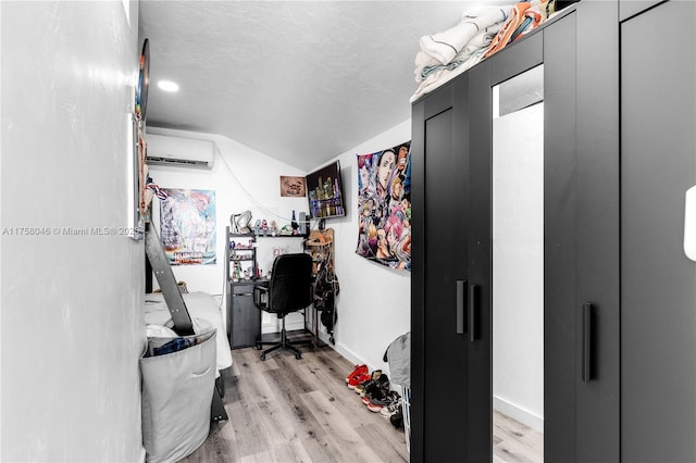 6830 SW 5th Ter, Miami, FL 33144 - office area with lofted ceiling, a wall mounted AC, a textured ceiling, light wood finished floors, and baseboards