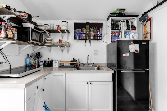 6830 SW 5th Ter, Miami, FL 33144 - kitchen with open shelves, freestanding refrigerator, a sink, light countertops, and white cabinets
