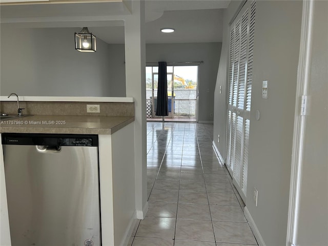 interior space with a sink, baseboards, and light tile patterned floors