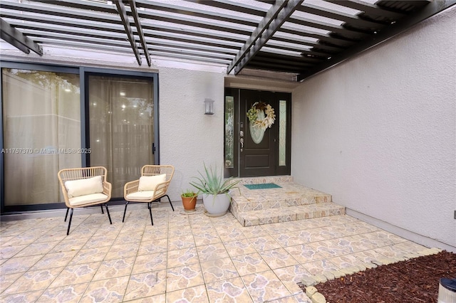 doorway to property featuring a pergola and stucco siding