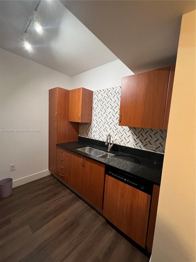 kitchen with decorative backsplash, dishwasher, dark countertops, dark wood-type flooring, and a sink