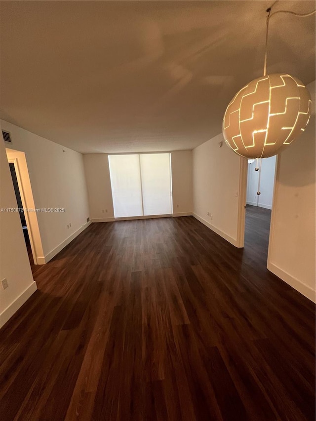 interior space with visible vents, baseboards, and dark wood-type flooring