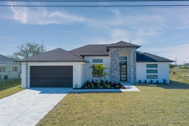 view of front of property featuring a garage, fence, decorative driveway, stucco siding, and a front yard