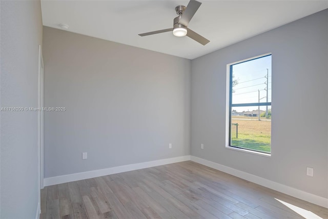 unfurnished room with ceiling fan, baseboards, and wood finished floors