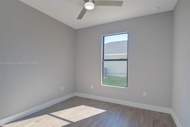 unfurnished room featuring a ceiling fan, baseboards, and wood finished floors