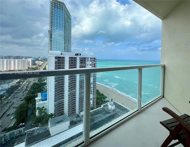 balcony featuring a water view, a beach view, and a city view