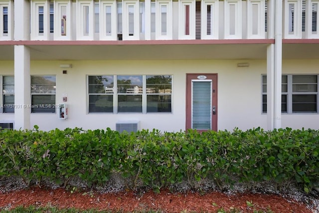 doorway to property featuring central AC and stucco siding