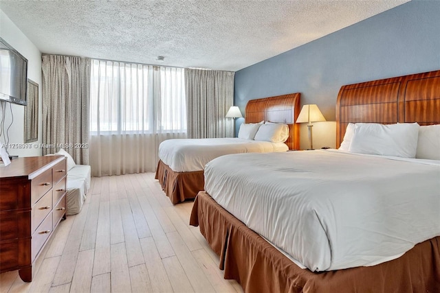 bedroom with a textured ceiling and light wood-style floors