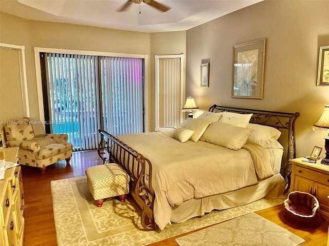 bedroom featuring access to exterior, a ceiling fan, and wood finished floors