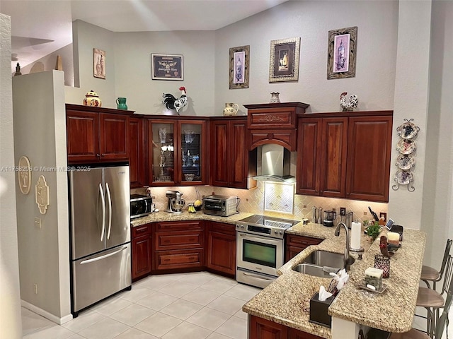 kitchen with stainless steel appliances, tasteful backsplash, a sink, a peninsula, and wall chimney exhaust hood