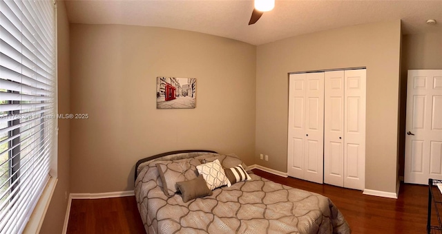 bedroom featuring a ceiling fan, a closet, baseboards, and wood finished floors