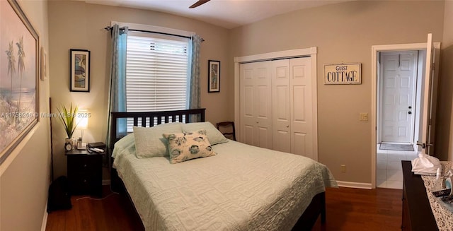 bedroom with dark wood-type flooring, a closet, a ceiling fan, and baseboards