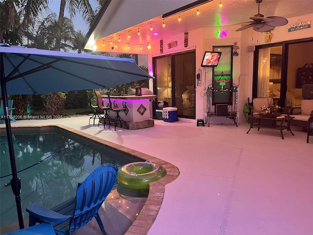 outdoor pool with a patio area and ceiling fan