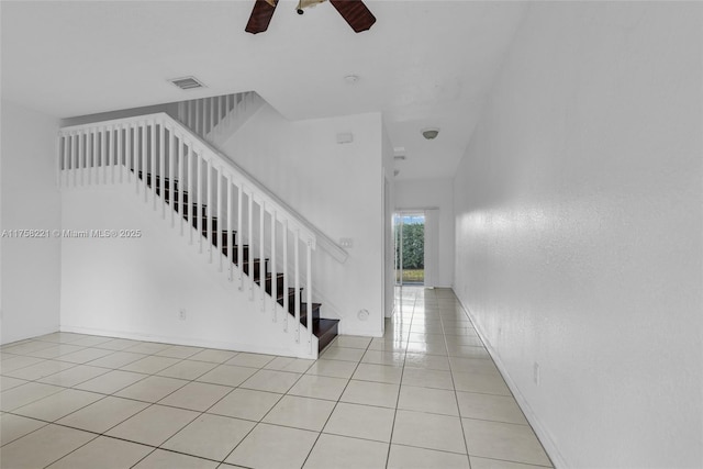 staircase with visible vents, ceiling fan, baseboards, and tile patterned floors