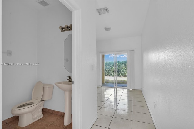 half bathroom with toilet, baseboards, visible vents, and tile patterned floors