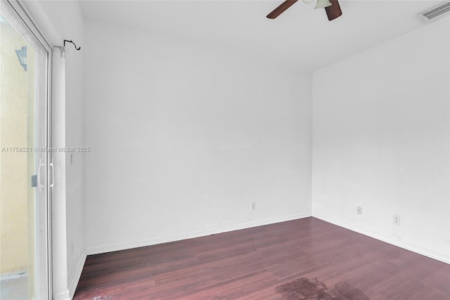 empty room with baseboards, wood finished floors, visible vents, and a ceiling fan