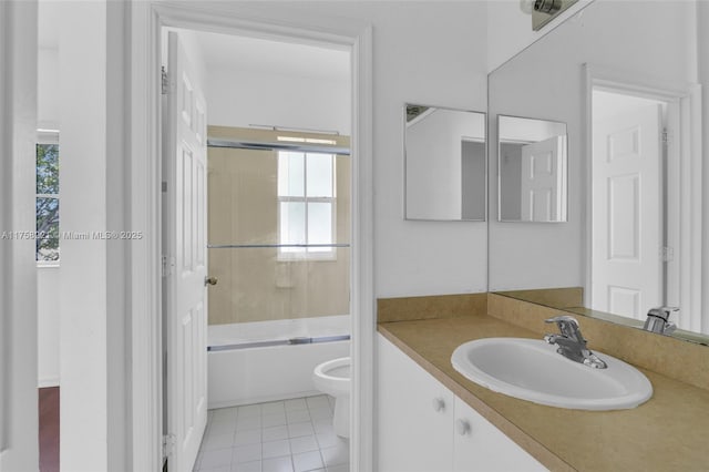 full bathroom with toilet, tile patterned floors, bath / shower combo with glass door, and vanity