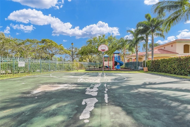 view of sport court featuring community basketball court, fence, and playground community