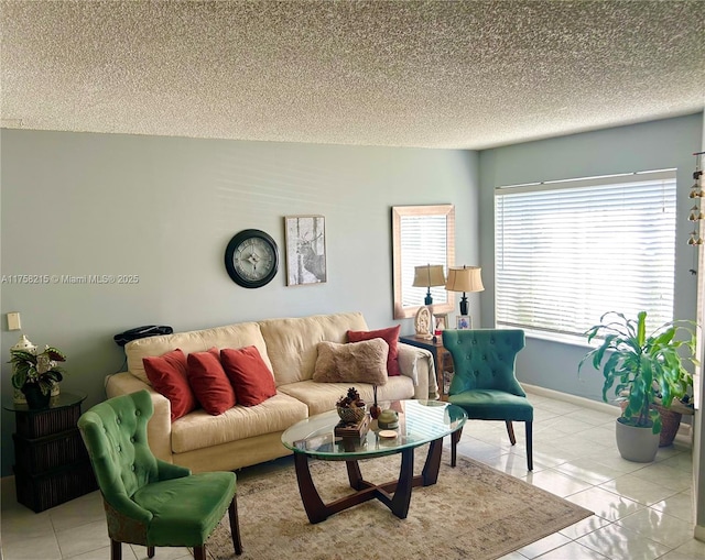 living area featuring a textured ceiling, baseboards, and light tile patterned floors