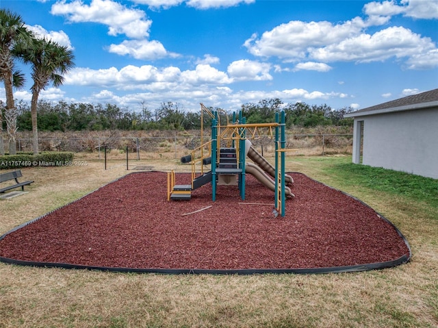 community jungle gym with a yard and fence