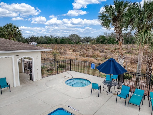 view of swimming pool with a community hot tub, fence, and a patio