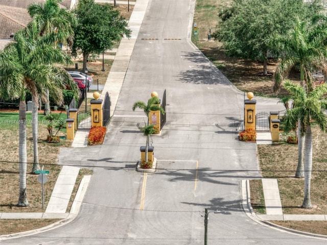 view of road with curbs, a gated entry, and a gate