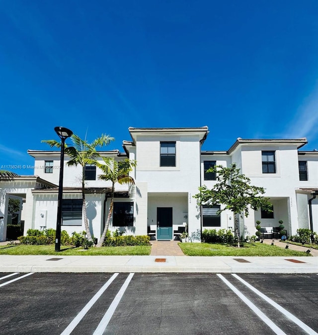 multi unit property featuring uncovered parking and stucco siding