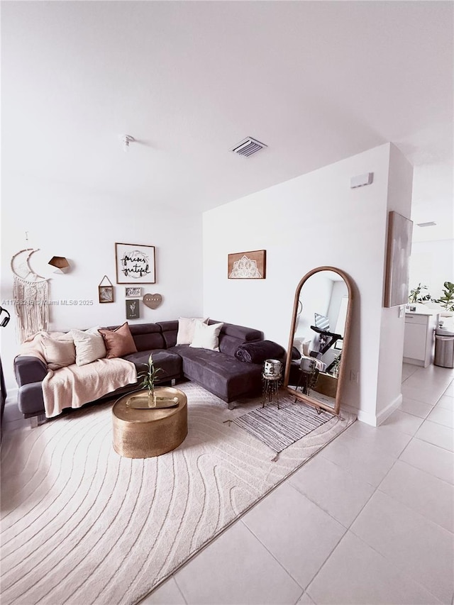 living area with light tile patterned floors and visible vents