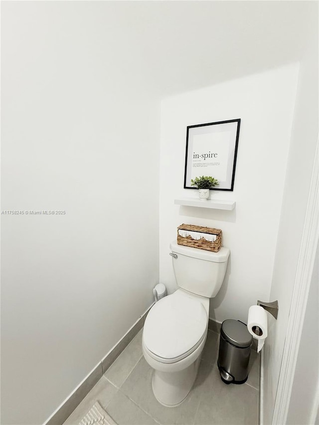 bathroom featuring toilet, tile patterned flooring, and baseboards