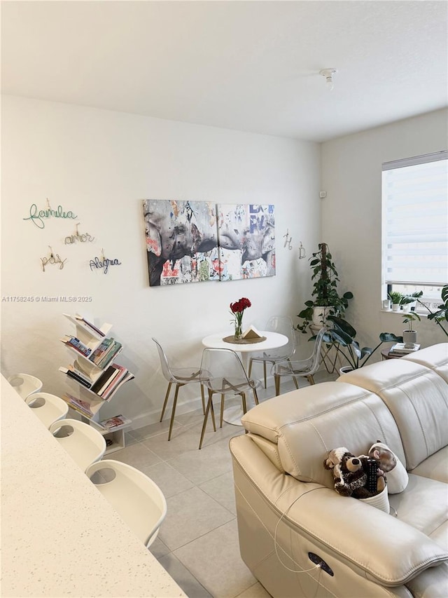 living room featuring light tile patterned flooring and baseboards