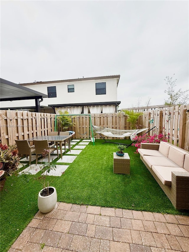 view of yard featuring a fenced backyard, an outdoor hangout area, and a patio