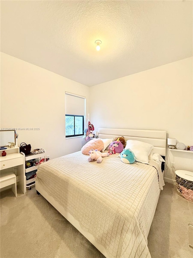 bedroom with light carpet and a textured ceiling