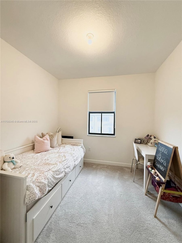 bedroom with light carpet, baseboards, and a textured ceiling