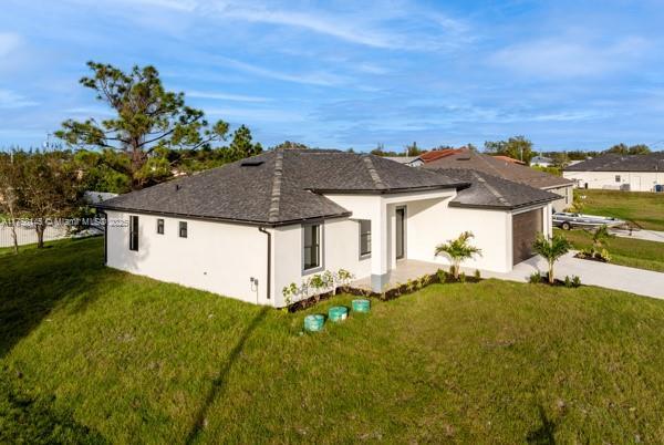 view of front facade featuring a garage, concrete driveway, a front lawn, and stucco siding