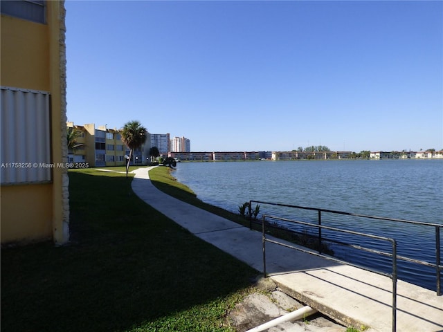 view of dock featuring a water view and a yard