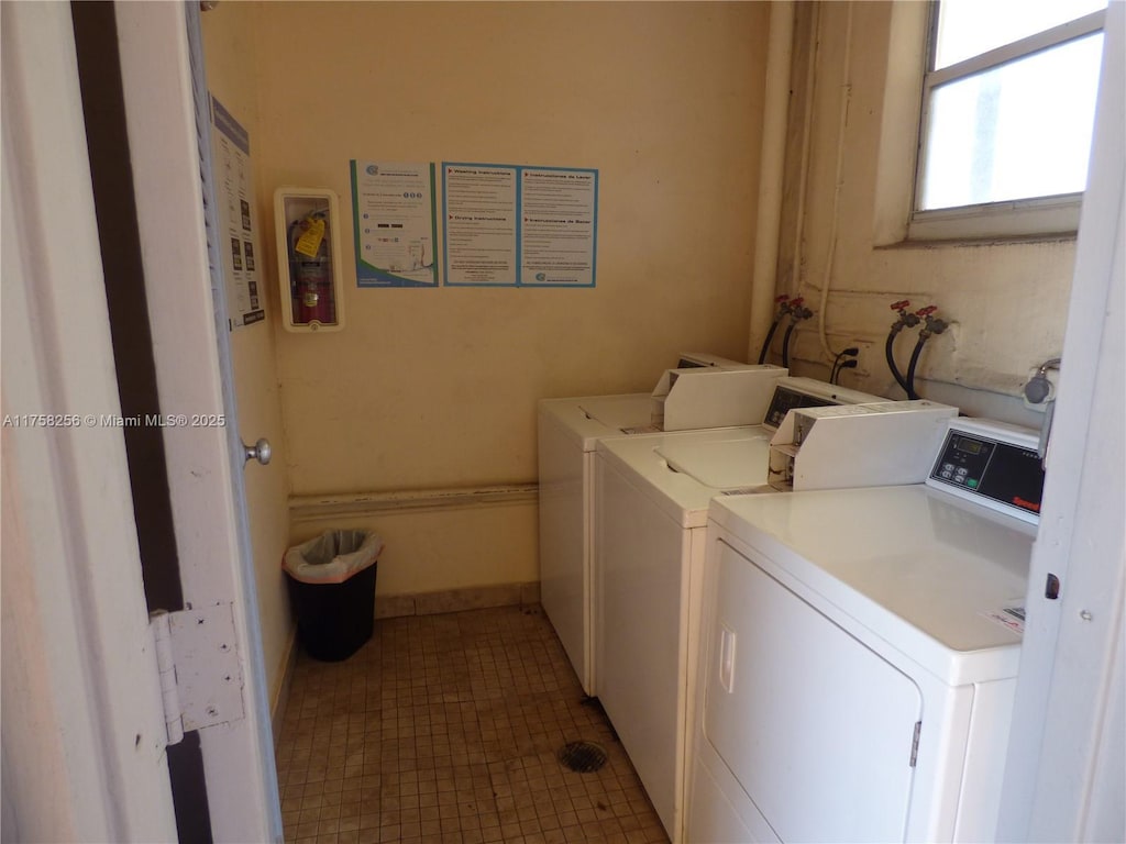 shared laundry area with tile patterned floors and independent washer and dryer