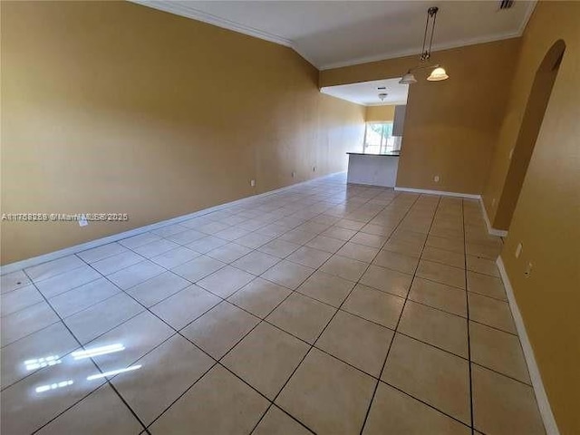 spare room with light tile patterned floors, arched walkways, lofted ceiling, baseboards, and crown molding