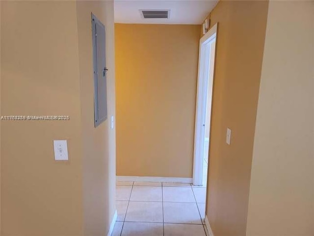 corridor with visible vents, baseboards, and light tile patterned floors