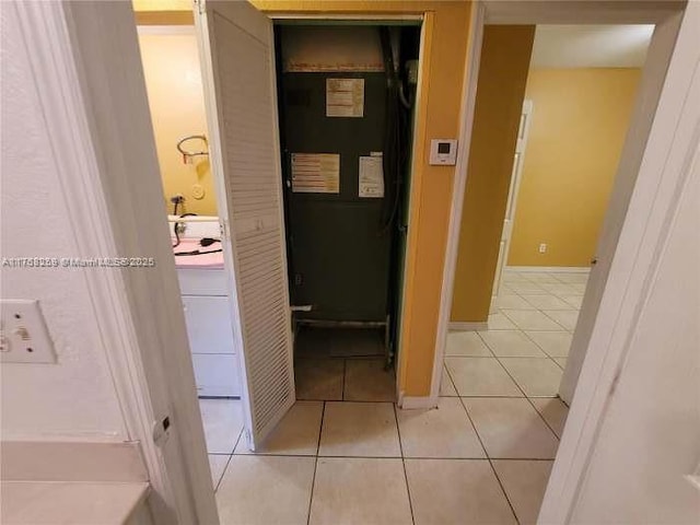 corridor with light tile patterned floors and baseboards