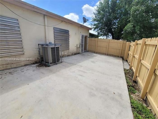 view of patio featuring central AC unit and fence