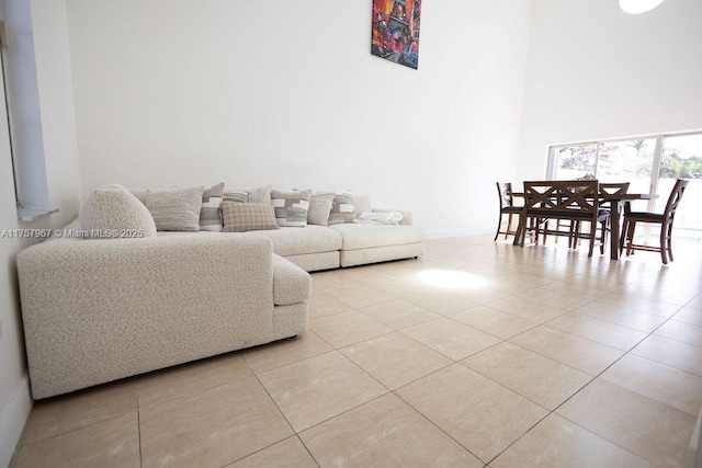 living area with light tile patterned flooring and a towering ceiling